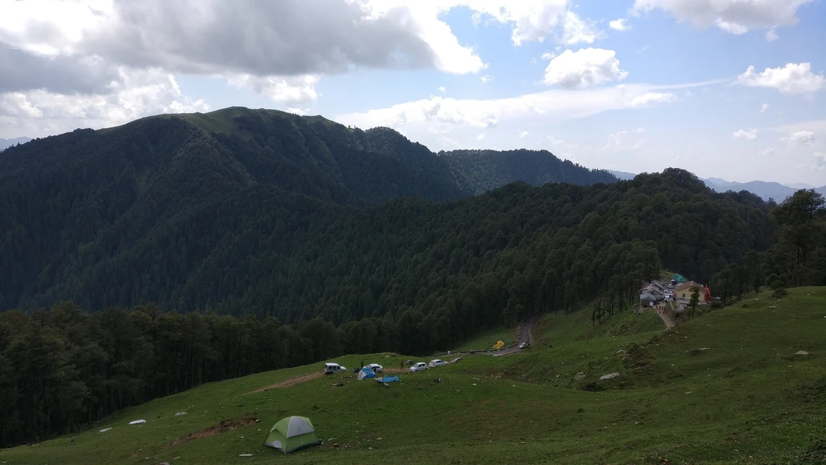 The meadow at Jalori Pass with tents and the temple