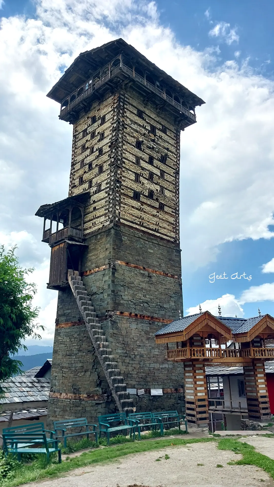The wooden tower of Chehni Kothi above the village roofs