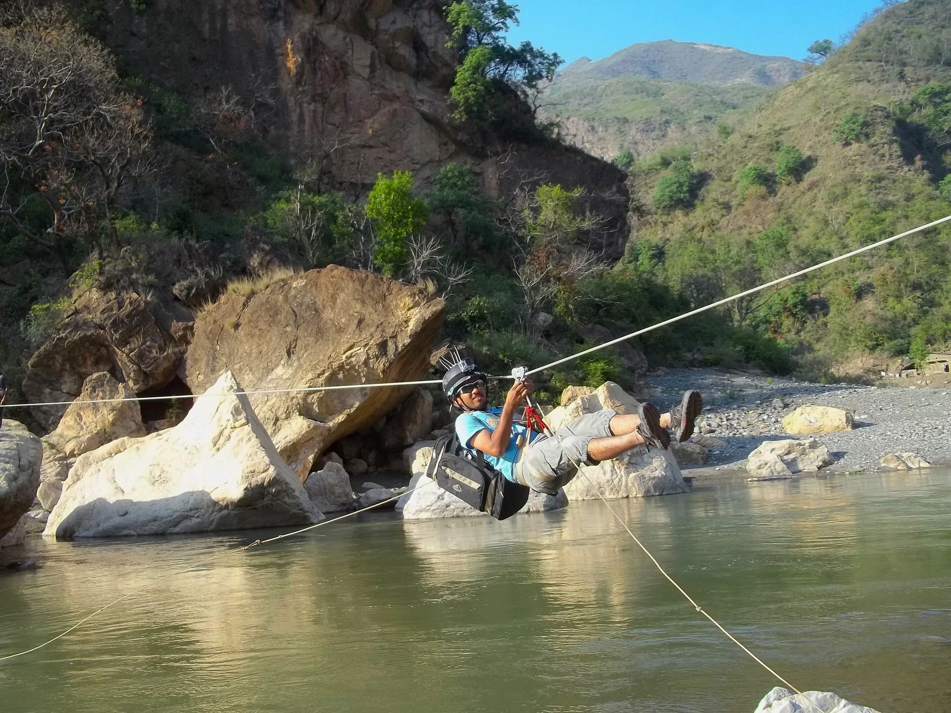A rider on a zip line over a river