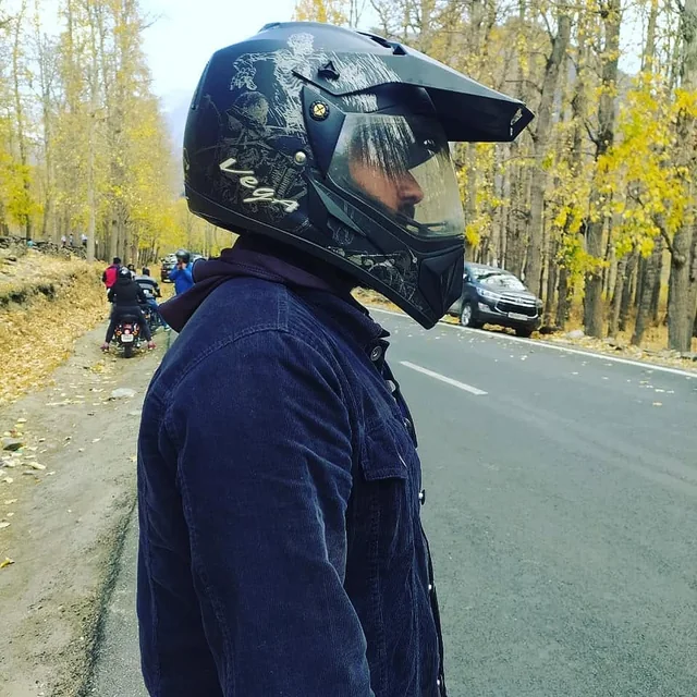 A rider in a helmet on an autumn road