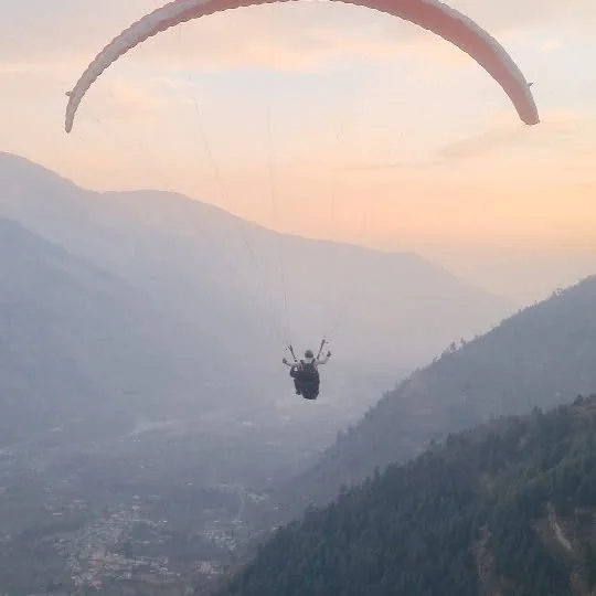 A paraglider in the evening haze over the valley