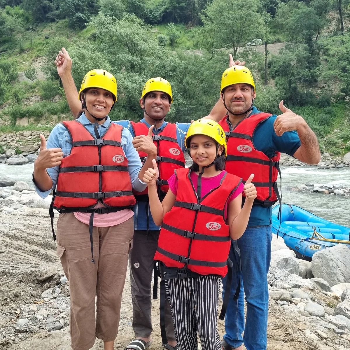 A family in life jackets on the riverbank