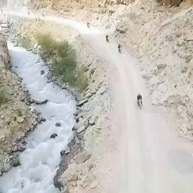 Riders on the road beside a mountain river