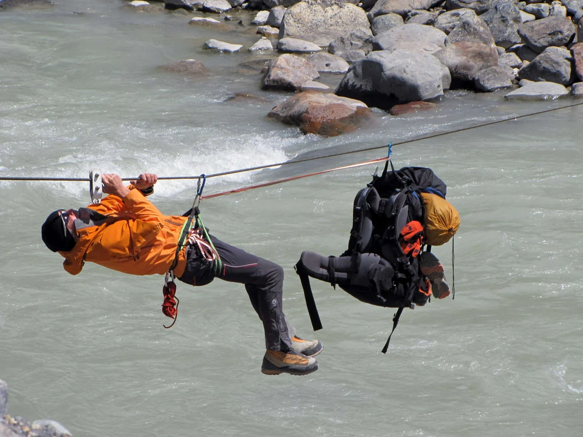 Crossing a mountain river hanging from a rope