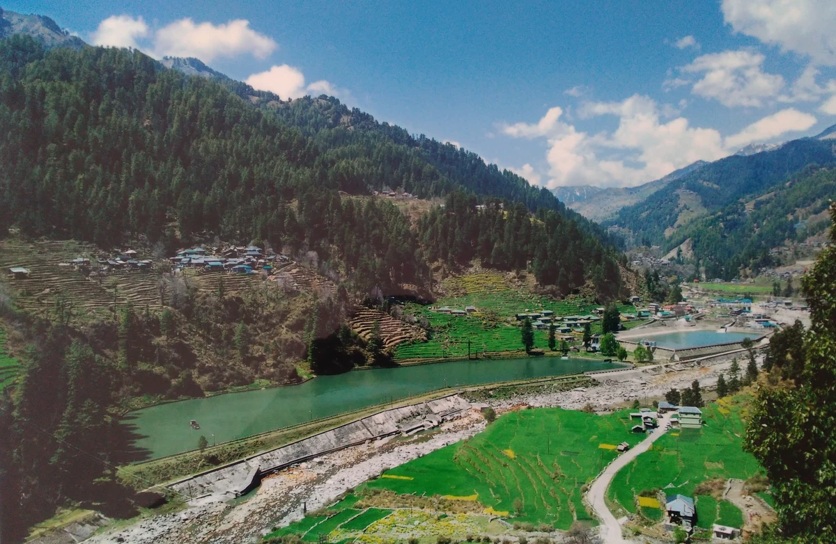 The green Uhl valley at Barot with the reservoir, fields and forested slopes under a blue sky