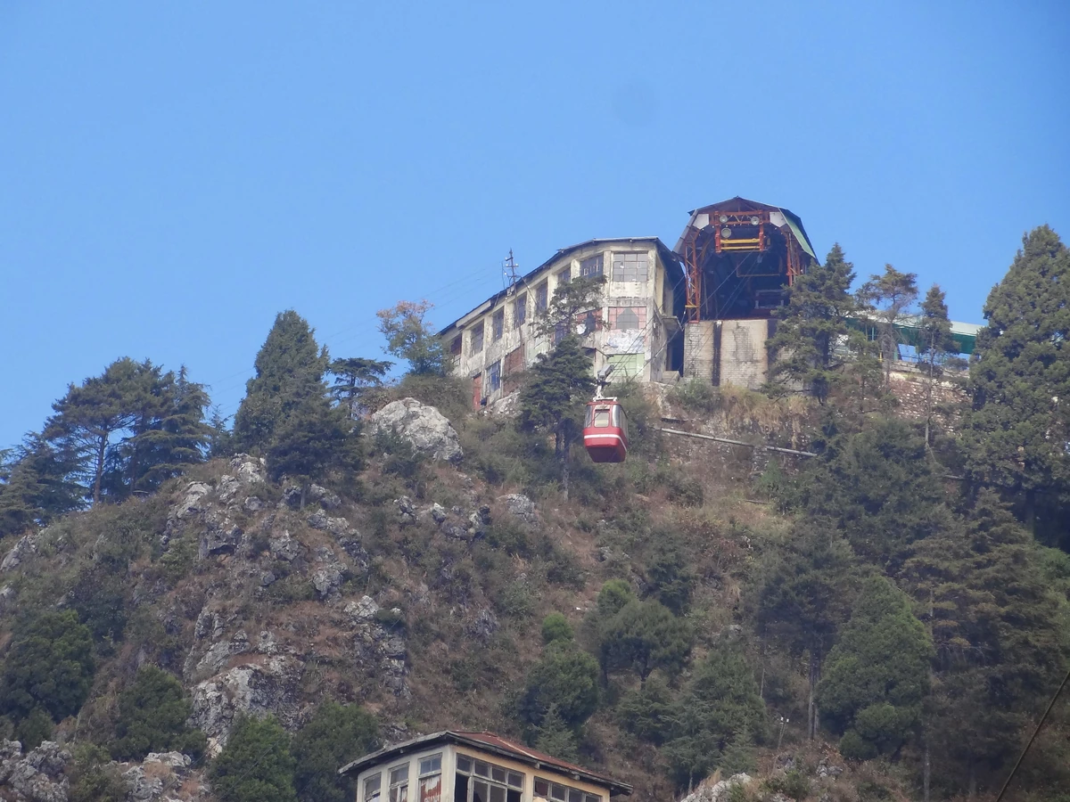 A red cable car arriving at the station on the rocky summit of Gun Hill above Mussoorie