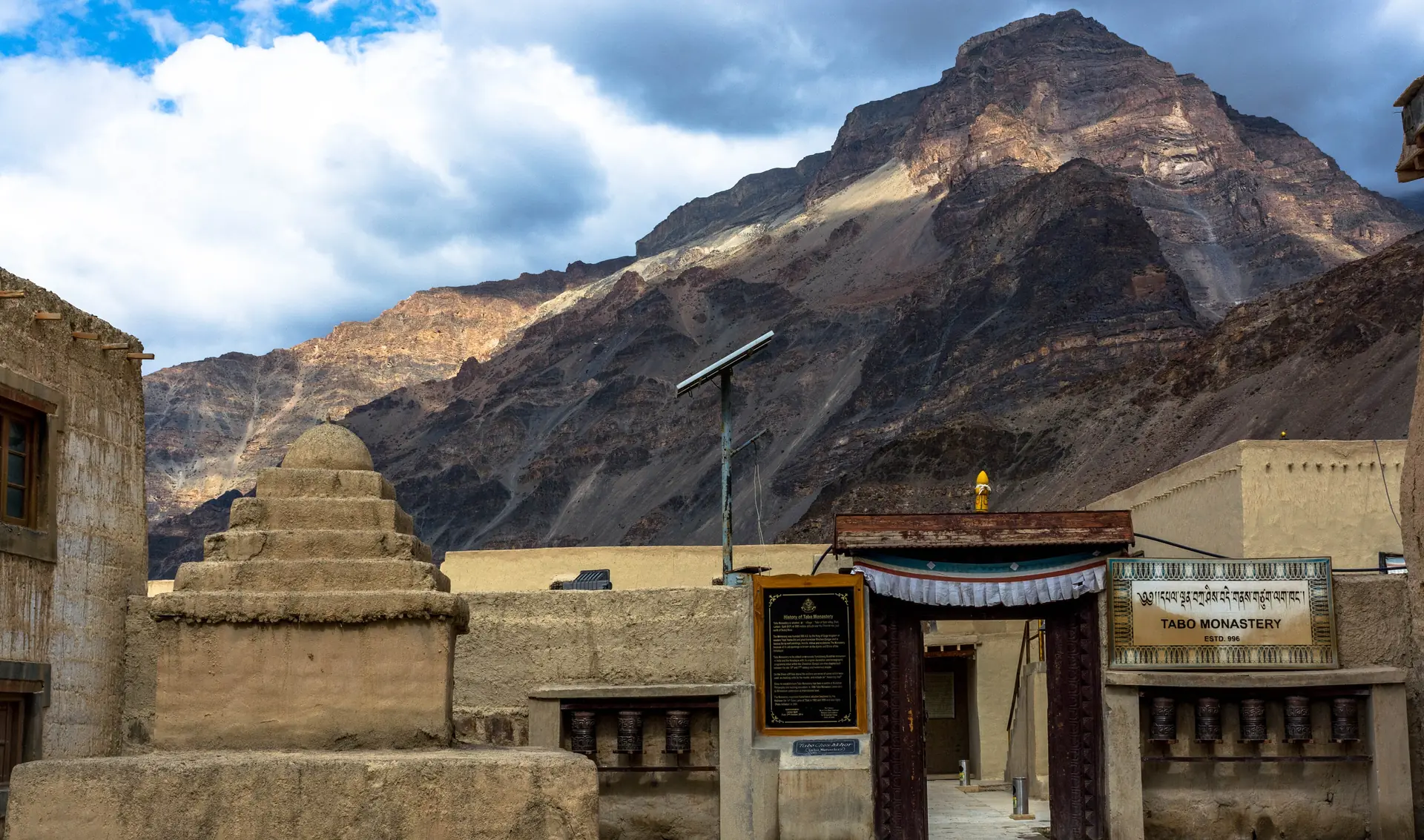 The entrance gate of Tabo Monastery with mud-built chortens and a mountain behind