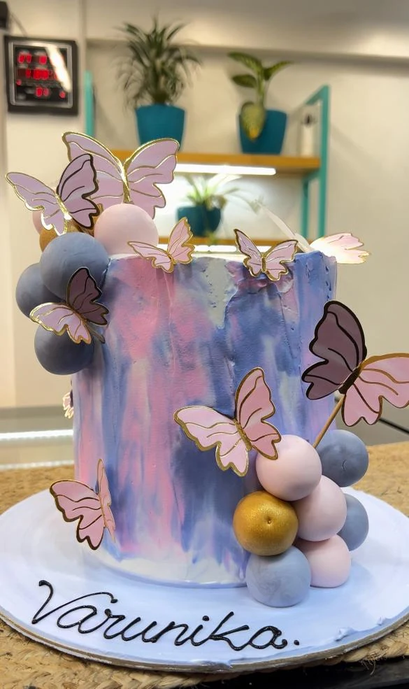 A lilac watercolour cake with paper butterflies