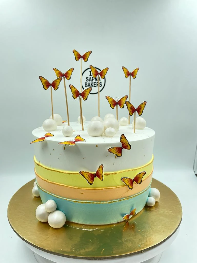 A pastel striped cake with golden butterflies