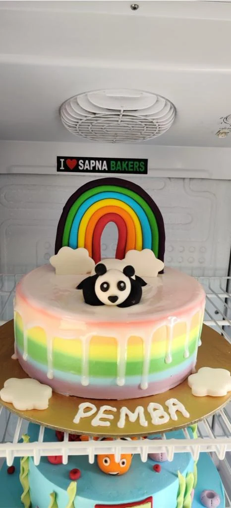 A rainbow drip cake with a panda