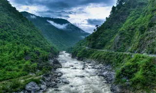 The Kosi river running over boulders through a steep green gorge near Almora