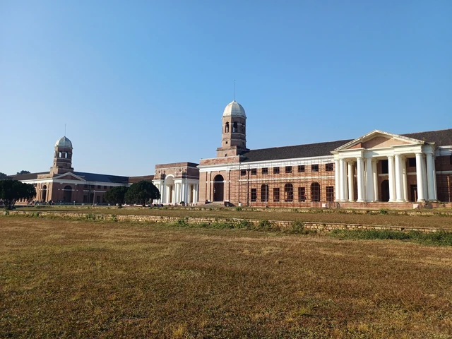 The Forest Research Institute's long red-brick front seen across a dry lawn under a clear blue sky