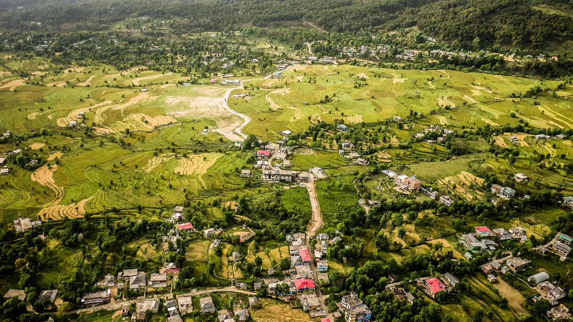 An aerial view of the green fields and houses of Bir in the Kangra Valley