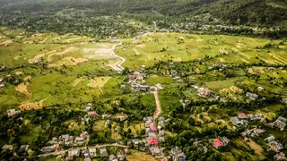 An aerial view of the green fields and houses of Bir in the Kangra Valley