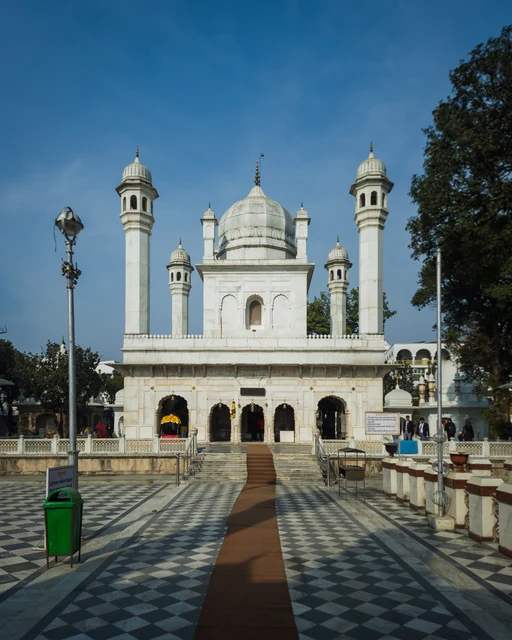 The white domed Guru Ram Rai Darbar with minarets across a chequered courtyard under a blue sky