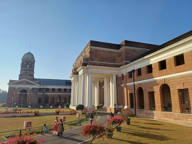 The red-brick Forest Research Institute with white columns and a domed tower beside a flower bed