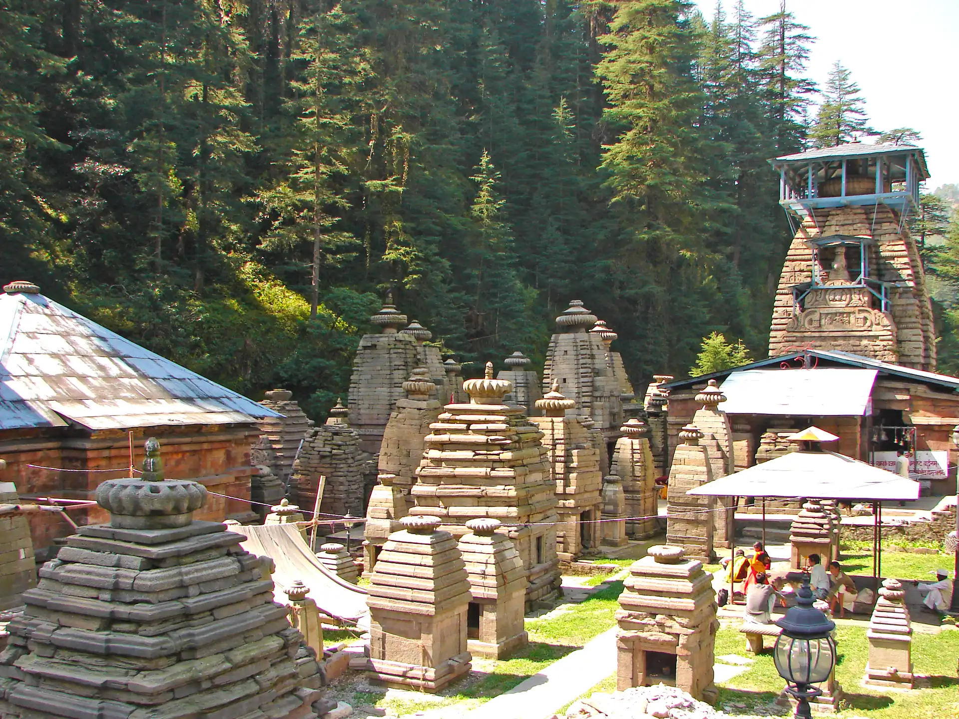 A cluster of old stone shrines with ribbed towers among deodar trees at Jageshwar