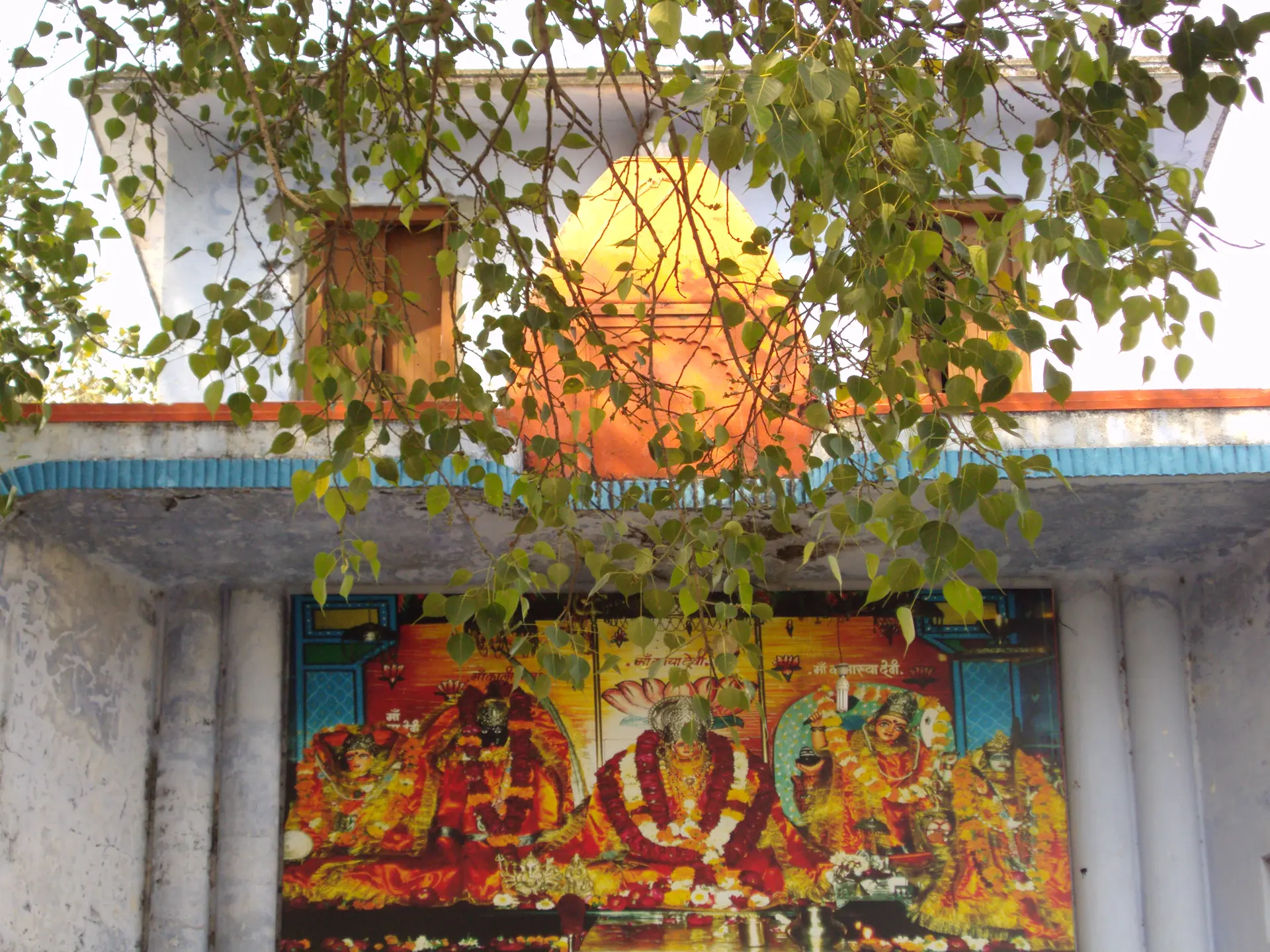 The painted entrance of the Maya Devi Temple, with a bright mural of the goddess under the leaves of a tree