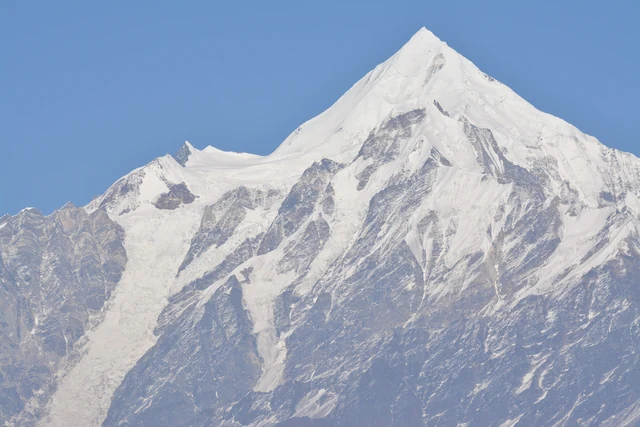 A sharp snow-covered Panchchuli peak against a clear blue sky