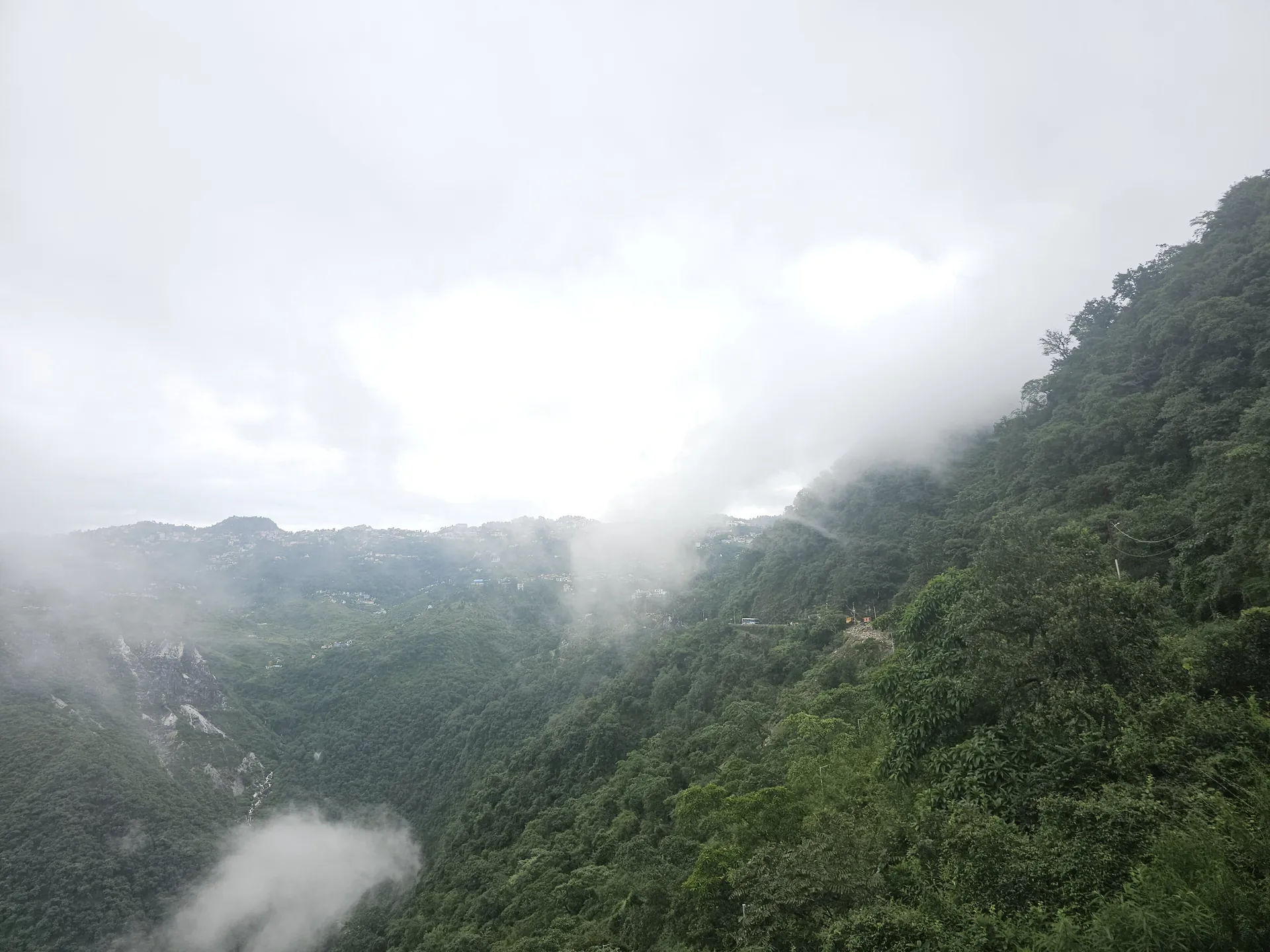 Mussoorie's houses and hotels stacked along a green ridge, with hazy hills behind