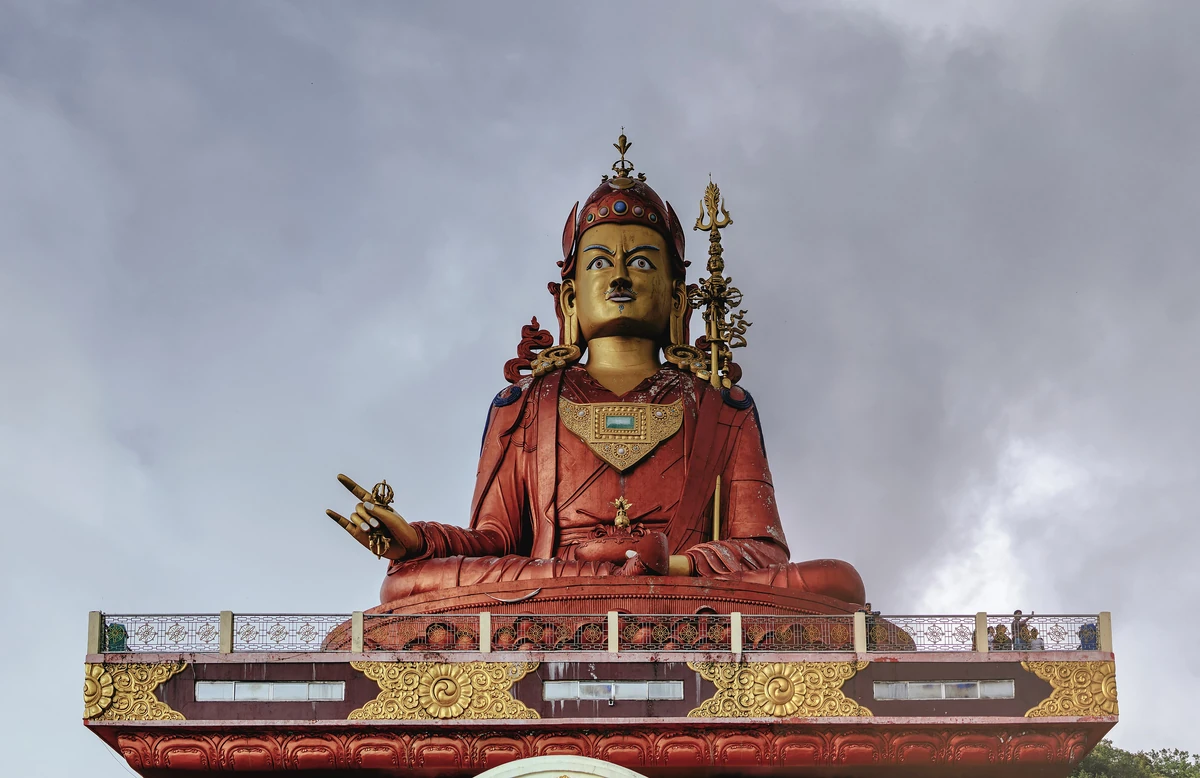 The huge copper-coloured seated statue of Guru Padmasambhava on its painted base on Samdruptse hill under a grey sky