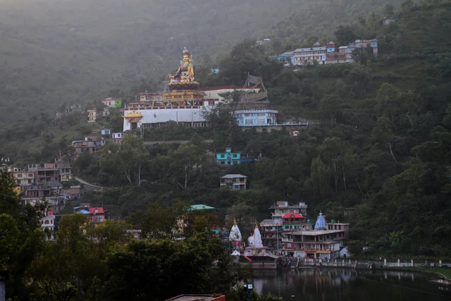 Rewalsar Lake with the Padmasambhava monastery and temples climbing the hillside above it.
