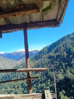 A wooden balcony looking out over the Sainj valley to the ranges