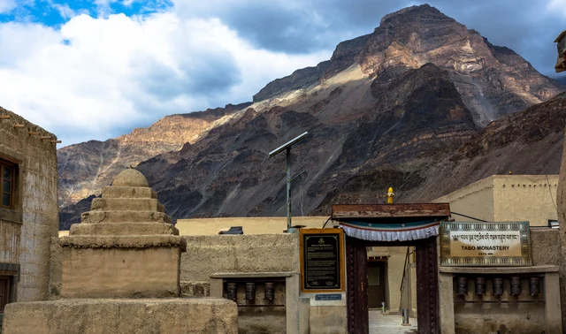 The entrance gate of Tabo Monastery with mud-built chortens and a mountain behind