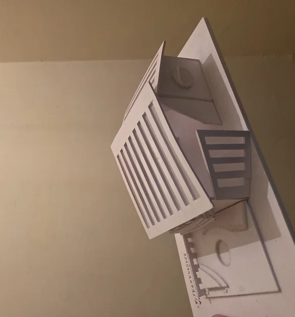 A white card model of a building with a ribbed facade